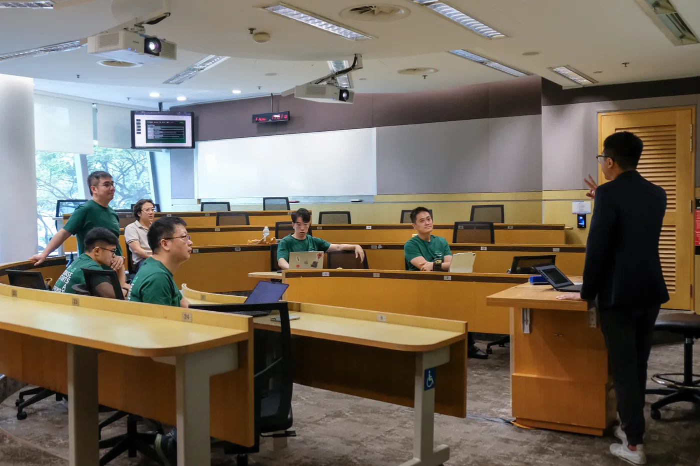 Hackathon teams working at laptops in the briefing room